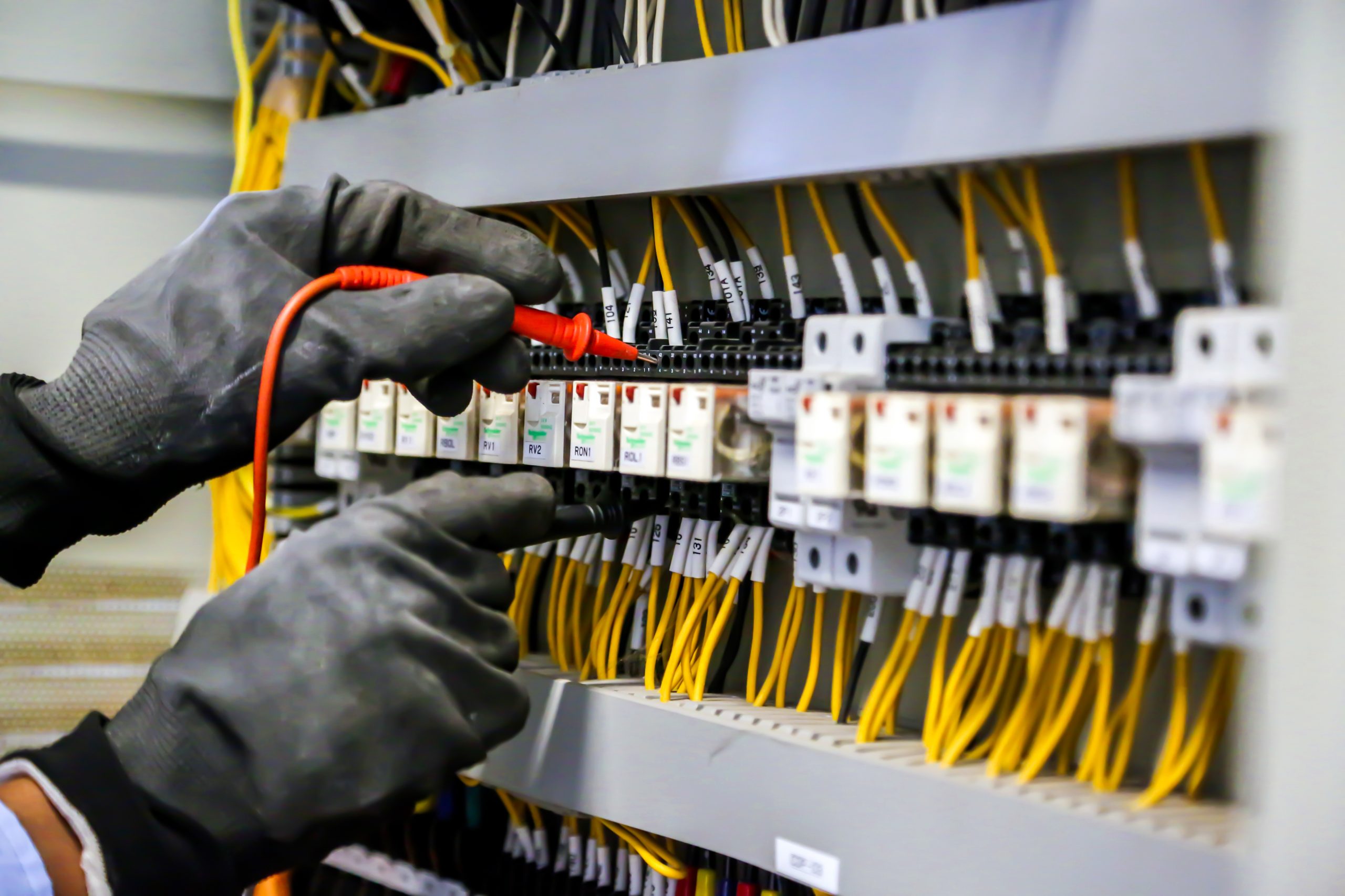 Electrical engineer using digital multi-meter measuring equipmen
