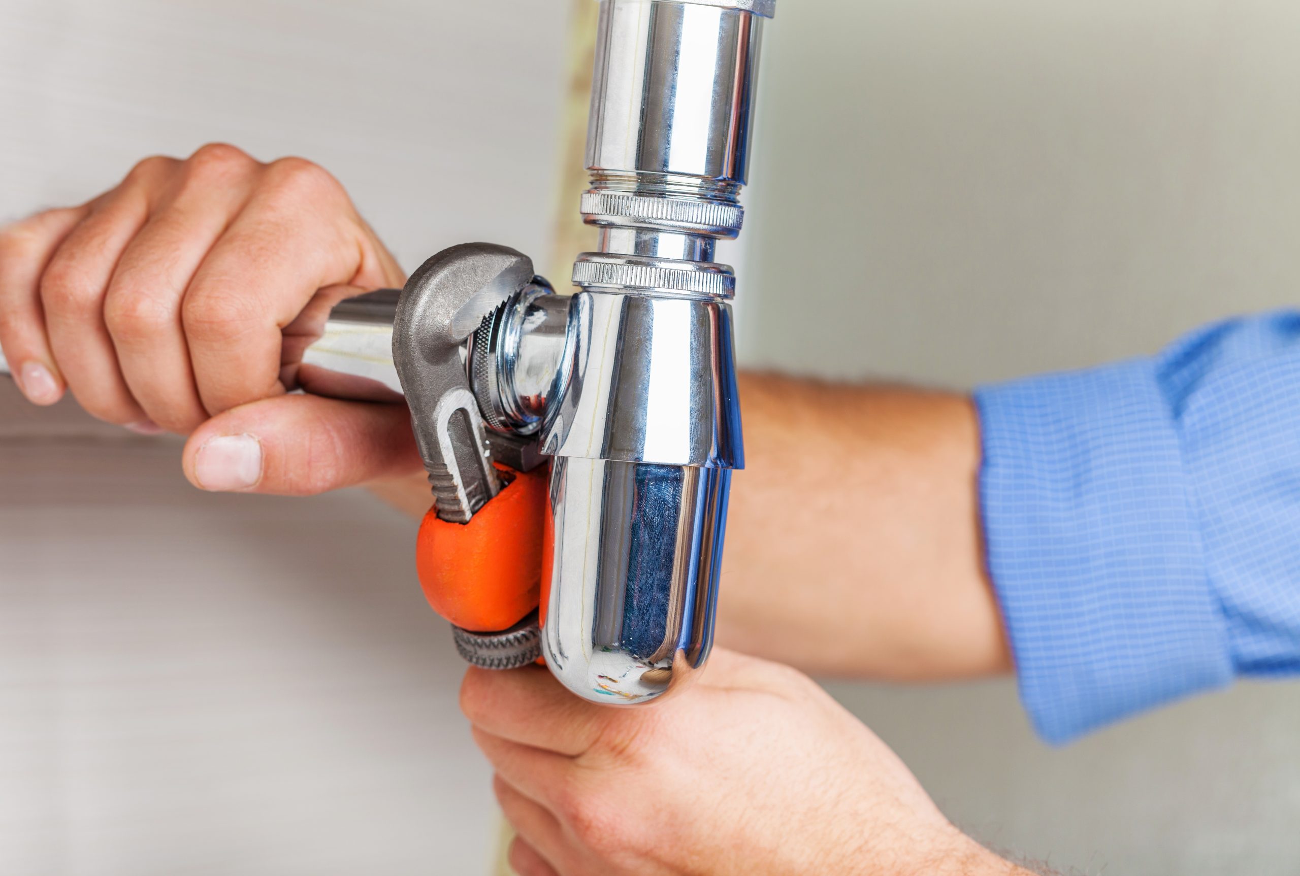 plumber hands fixing water tap background scaled