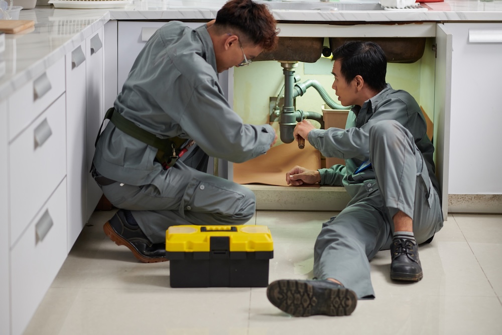 Plumbers working on pipes in Singapore, providing expert leak detection and clog removal services